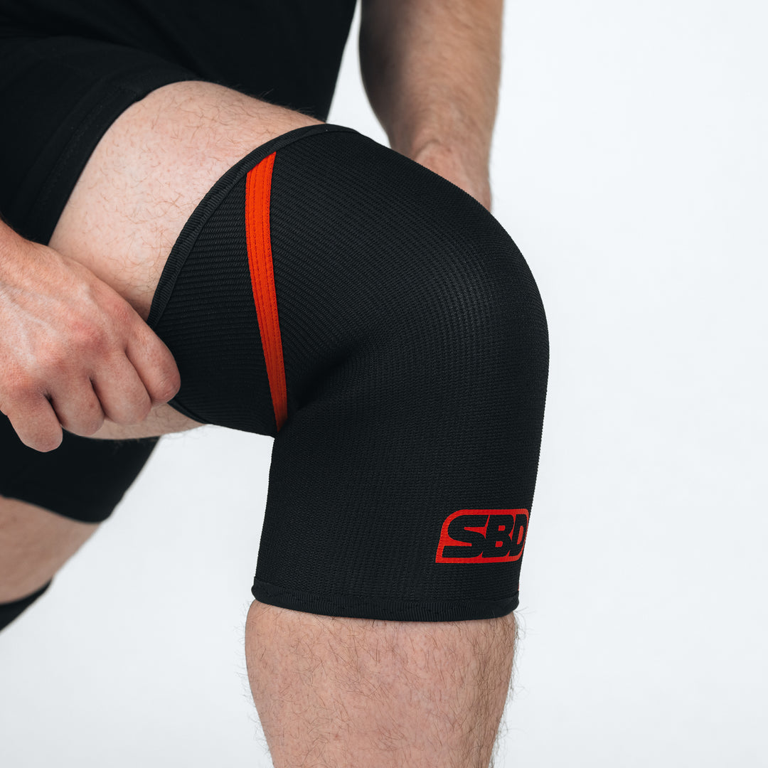 SBD Powerlifting Knee Sleeves 7mm – detail van het aantrekken rond de knie