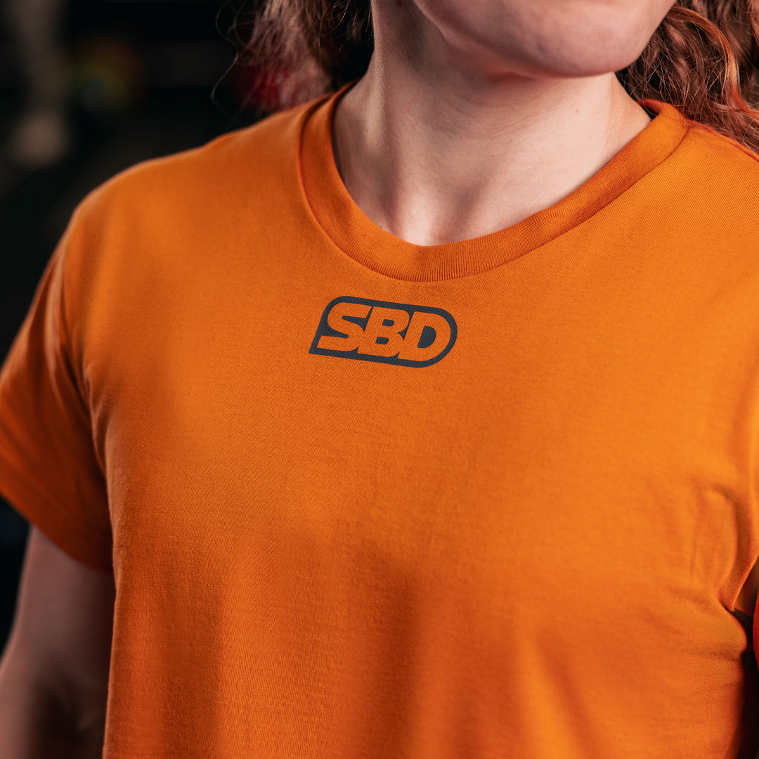 SBD Crop Top - Forge Limited Edition – detail van de halslijn en het grijze SBD-logo
