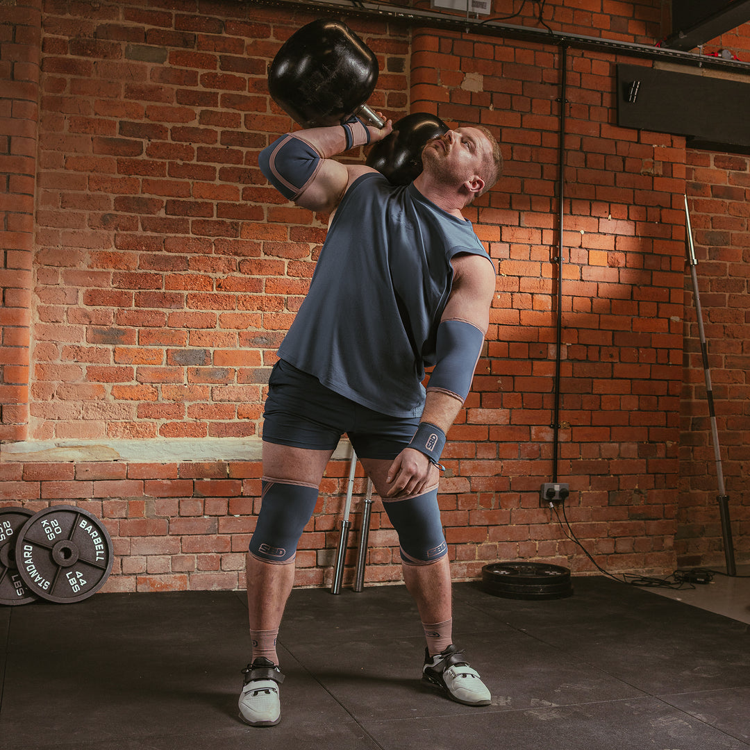 SBD Elbow Sleeves - Serenity Limited Edition – man draagt de sleeves tijdens een dumbbelloefening