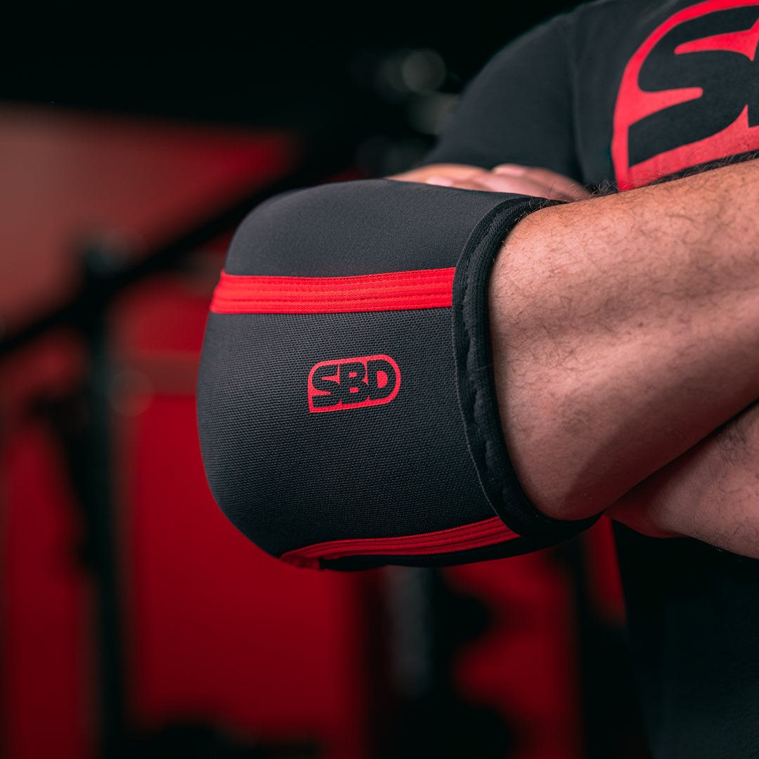 SBD Elbow Sleeves – detail van het rode logo op de gedragen sleeve