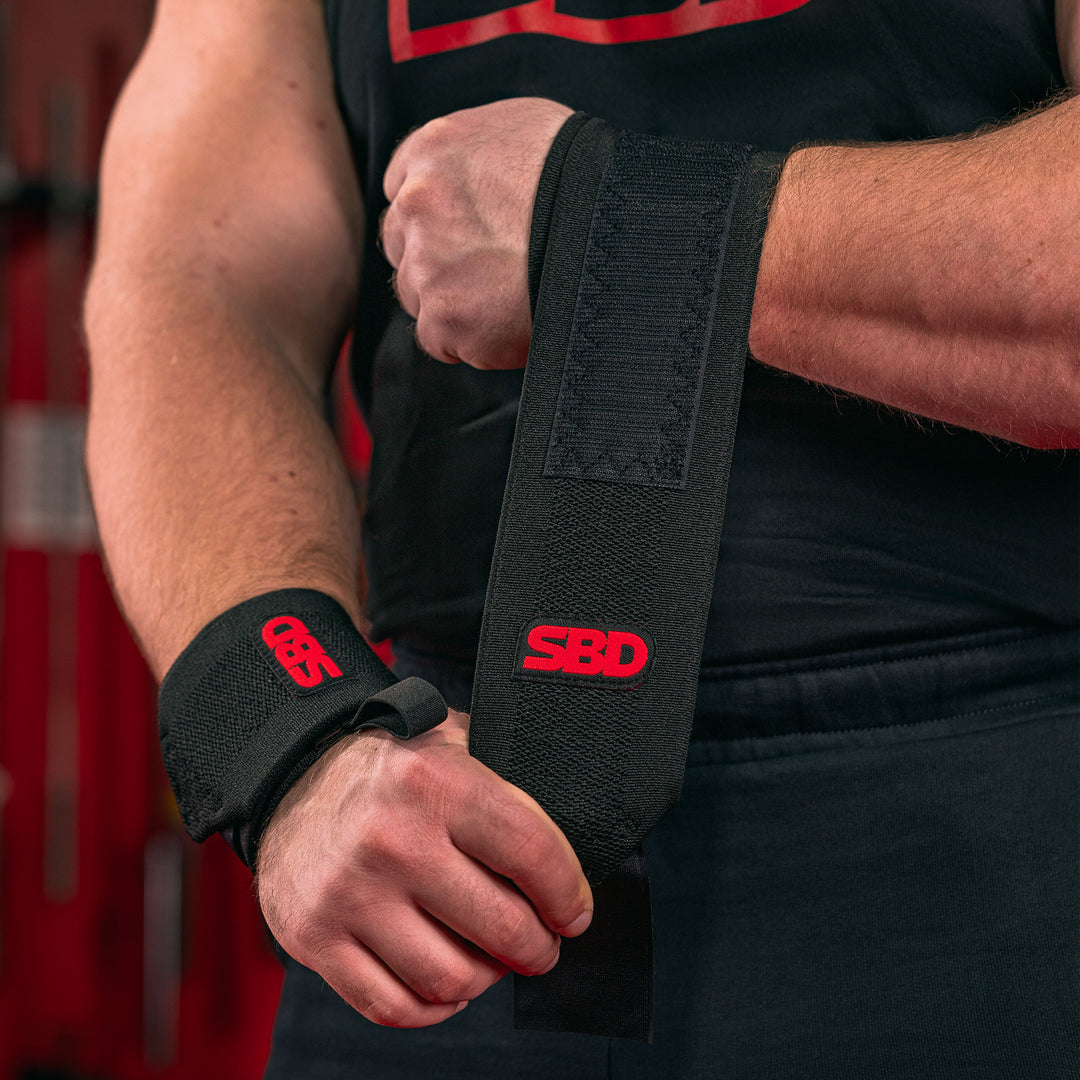SBD Wrist Wraps – zwarte Flexible wrap met rood logo wordt aangebracht