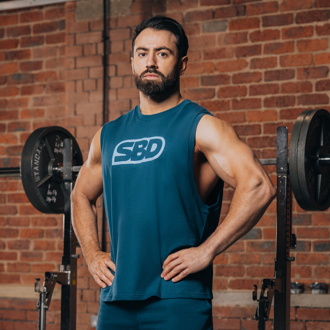 SBD Tank Shirt - Reflect Limited Edition – blauwgroene tanktop met wit SBD-logo gedragen door een man