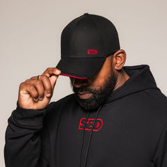 Mannelijk model draagt de SBD Baseball Cap Classic in zwart – studiofoto 1