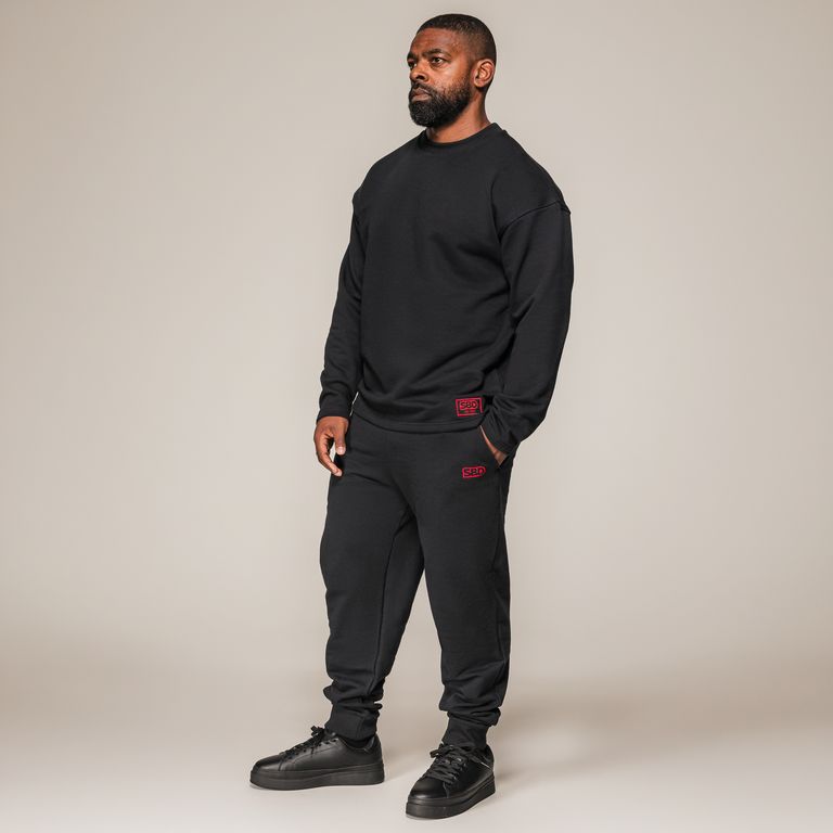 SBD Sweatshirt Classic – zwart sweatshirt gedragen door een man, volledige houding