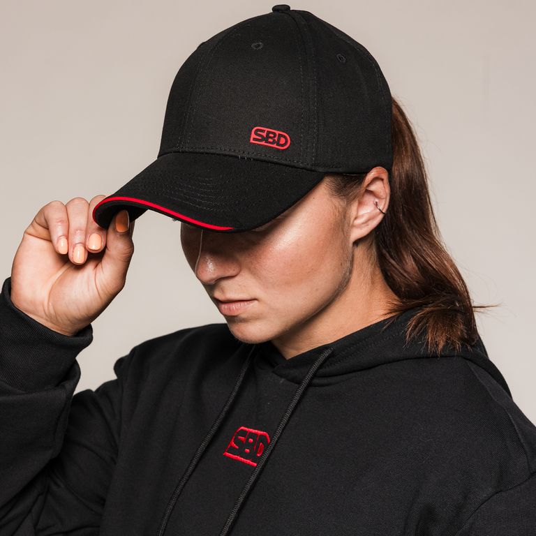 Vrouwelijk model draagt de SBD Baseball Cap Classic in zwart – studiofoto 1