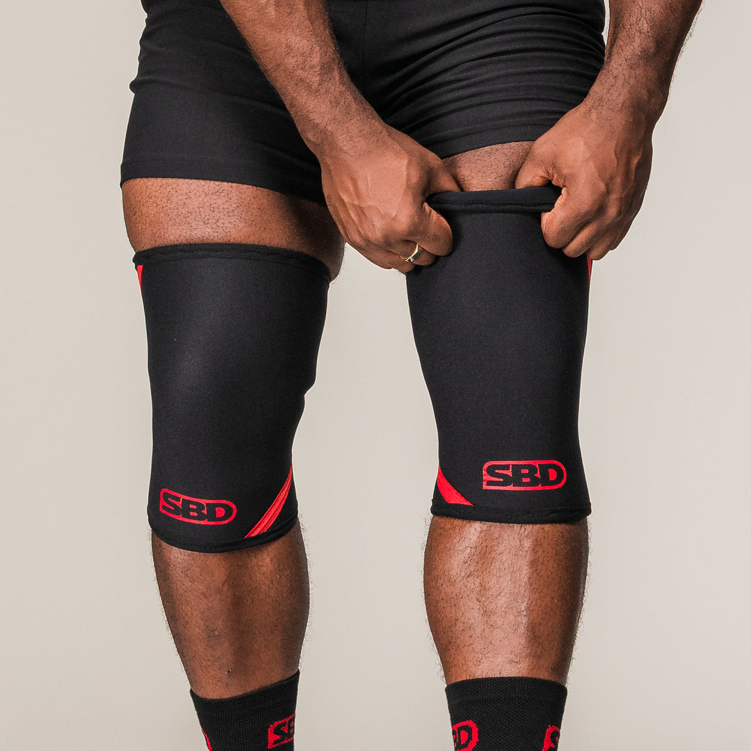 SBD Knee Sleeves 7mm in zwart-rood, gedragen op beide knieën