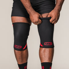 SBD Knee Sleeves 7mm in zwart-rood, gedragen op beide knieën