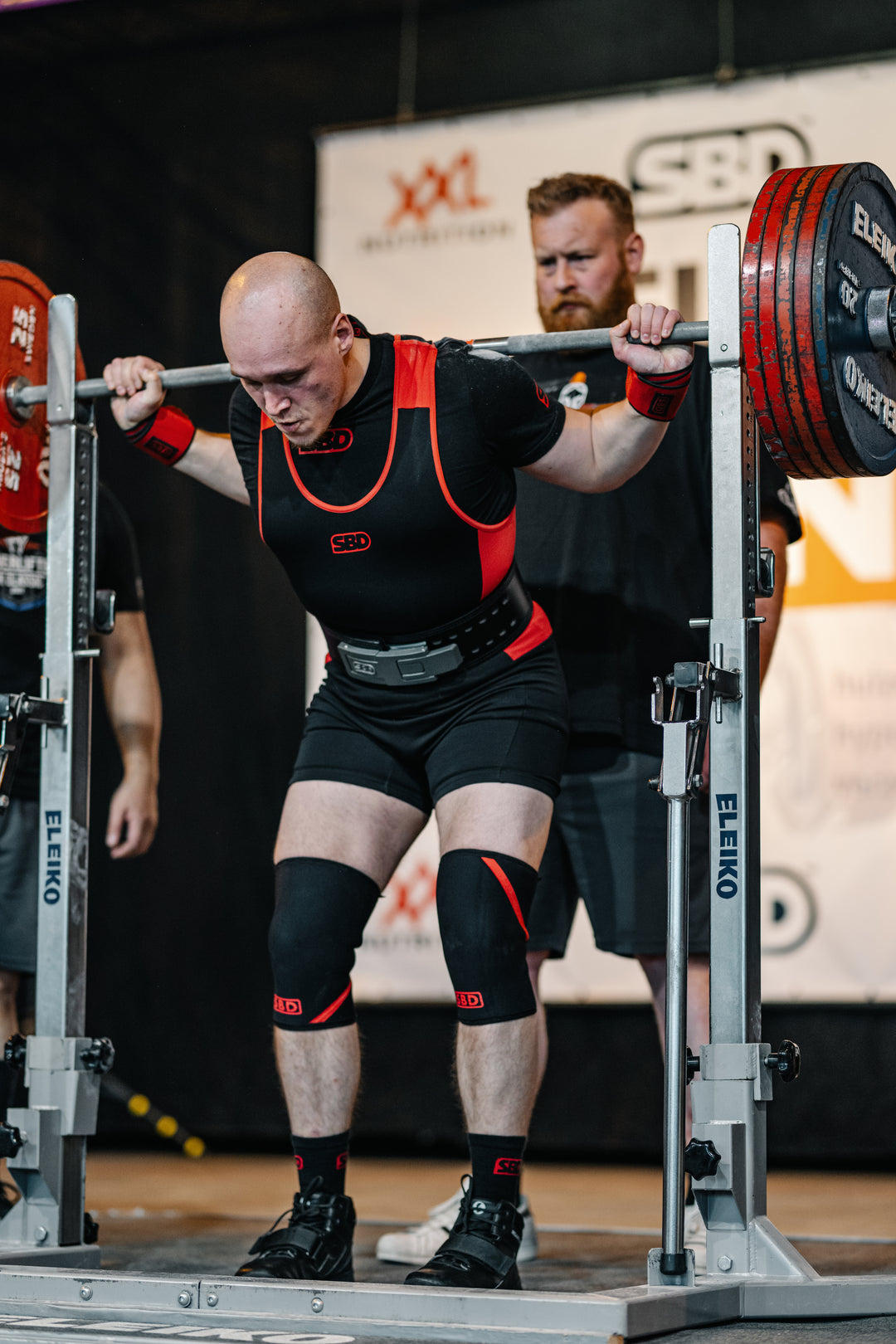 SBD Powerlifting Singlet Classic – rood-zwarte uitvoering gedragen tijdens een squatwedstrijd