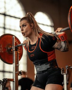 SBD Powerlifting Singlet Classic – damesmodel in zwart-rood tijdens een wedstrijd