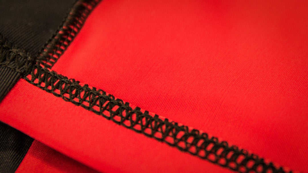 SBD Singlet Classic – detail van de rode stof en beenafwerking